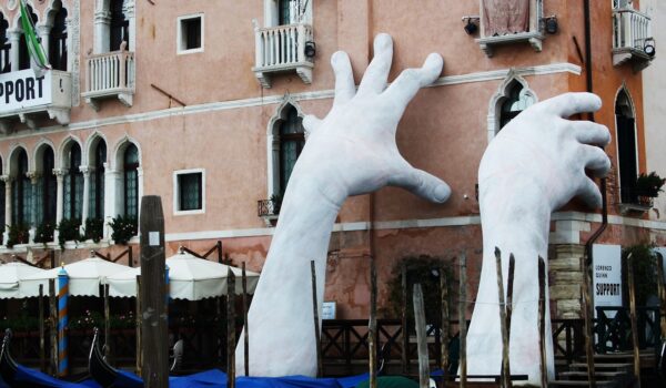 Scultura che sostiene edifici italiani a Venezia che affondano a causa del cambiamento climatico